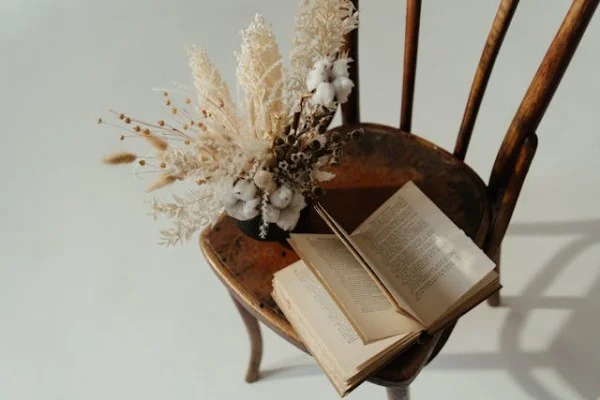 Cadeira de madeira cipreste com livro e vaso de flor